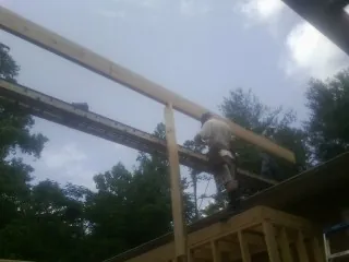 Carpenter setting a ridge beam over a new addition frame — Ice Dam Removal by Roofing Brothers in Great Falls